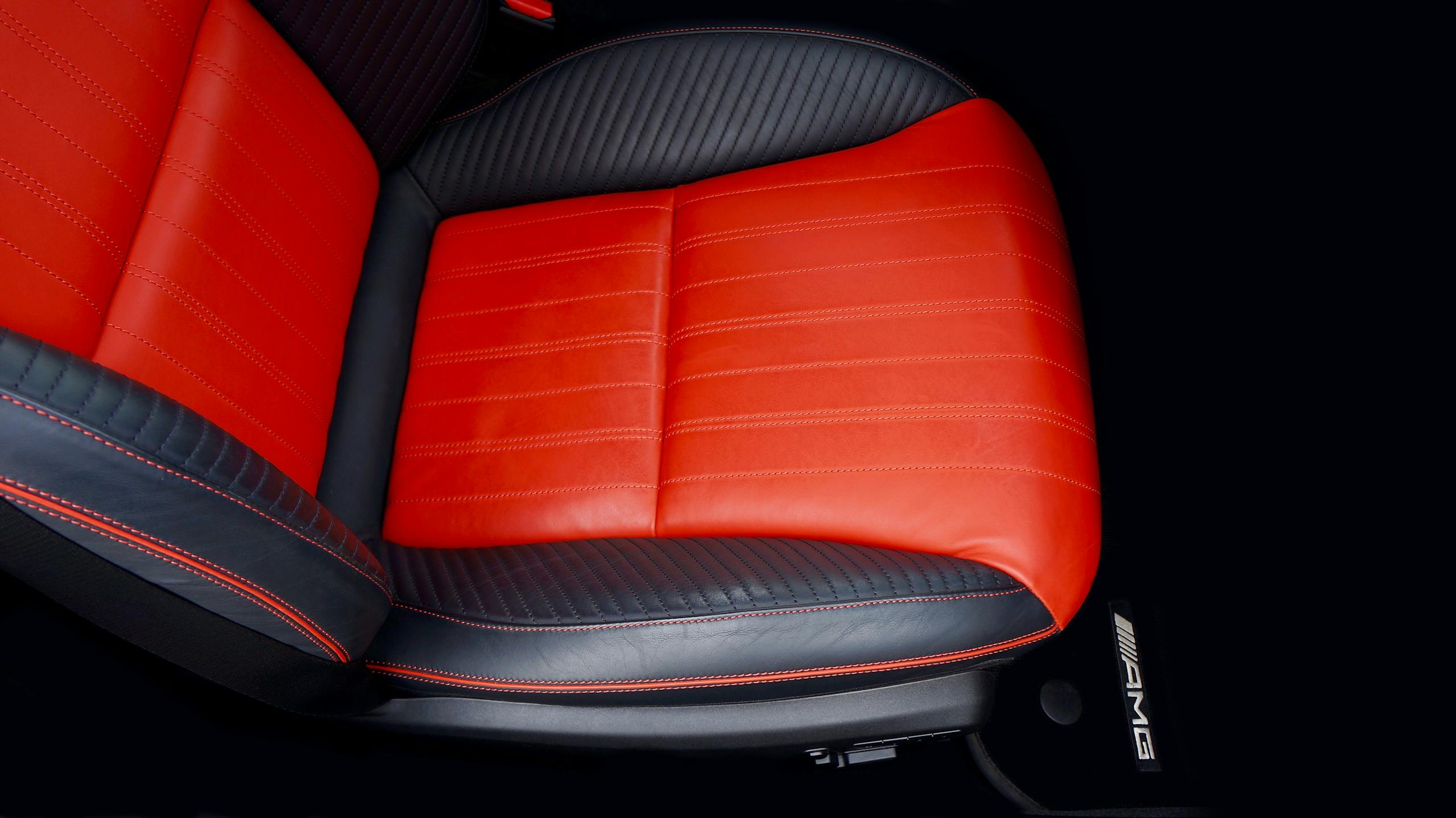 Top view of a luxury car seat with red and black leather, emphasizing modern automotive design.