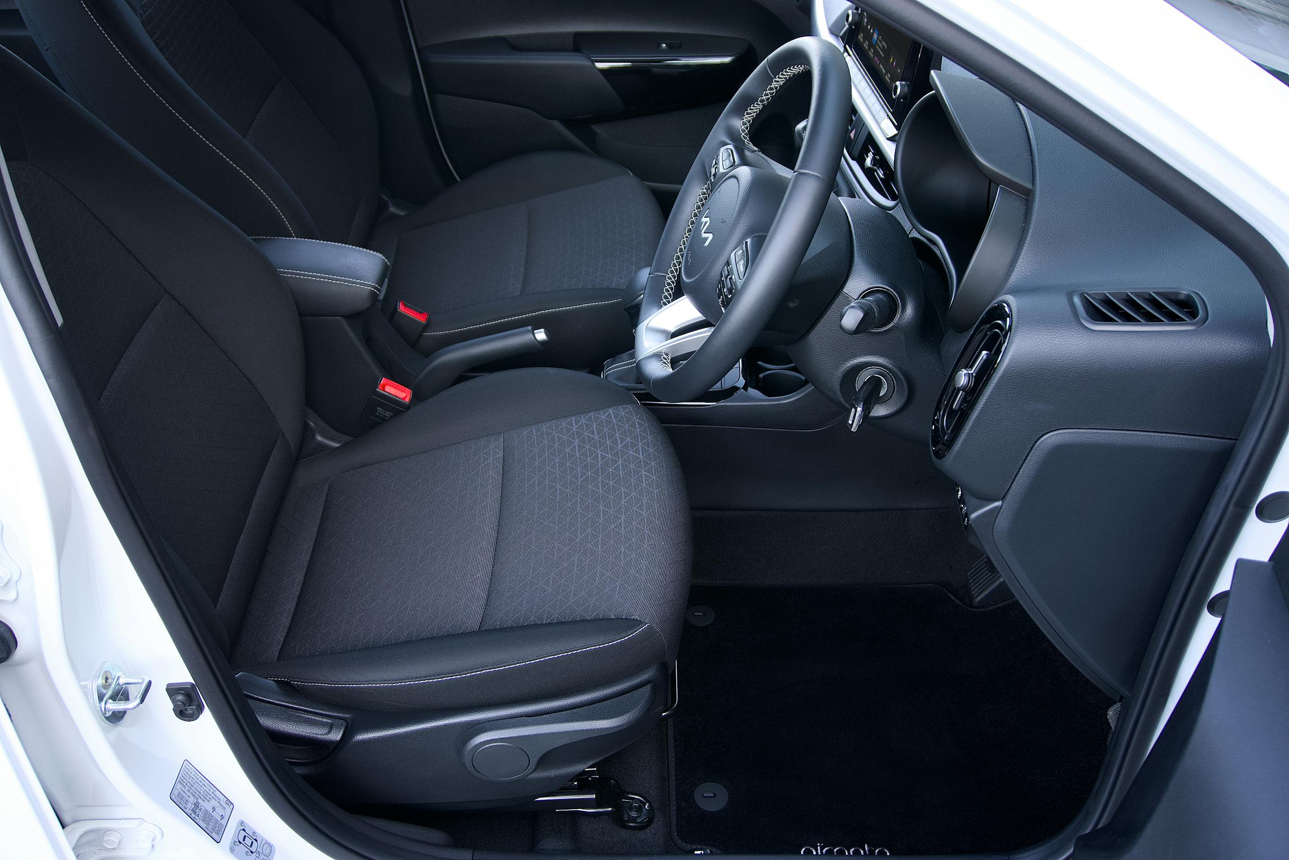 High angle view of a car interior showcasing black seats, dashboard, and steering wheel.